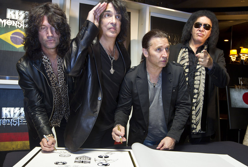 KISS, from left, Tommy Thayer, Paul Stanley, Eric Singer and Gene Simmons, sign their book Wednesday in London.