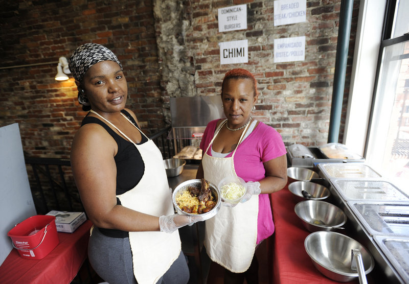 Aidalina Costoso, left, and Lourdes Suero of La Cocina Dominicana show off the barbecue beef ribs with rice and peas, sweet plantains and cabbage salad during a recent lunch hour. The eatery opened for business a few weeks ago.