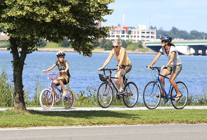 Kendra Drinkwater, right, her daughter, Sage, 9, and her mother, Paula Marquis of Portland, do some biking Thursday along Back Cove in Portland.