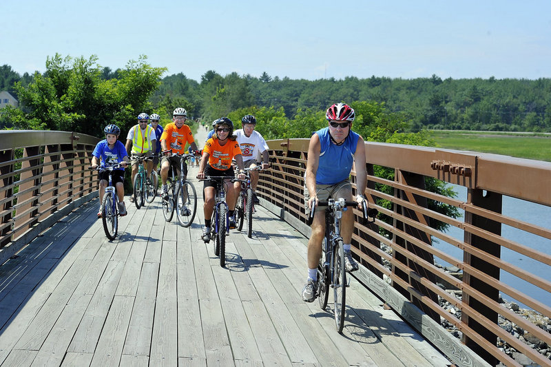 Dan Stewart, right, bicycle and pedestrian program manager for the Maine Department of Transportation, leads cyclists over the Eastern Trail bridge at Scarborough Marsh last summer. Stewart said it is premature to say how state programs will be affected by cuts proposed in a new $120 billion federal transportation plan.