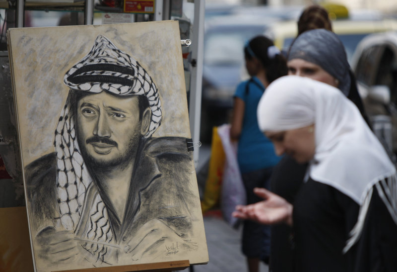 A drawing of the late Palestinian leader Yasser Arafat is displayed on a street corner in the West Bank city of Ramallah on Thursday. Palestinian leaders want more information before deciding on digging up Arafat’s body.