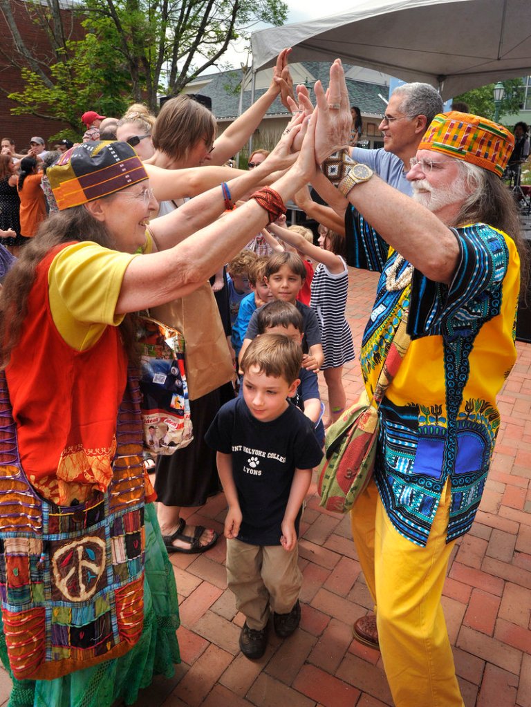 Dorothy and Paul Fortin of Brunswick, in festive dress, help make a tunnel for kids to dance through during a performance by the Dan Zanes Band.