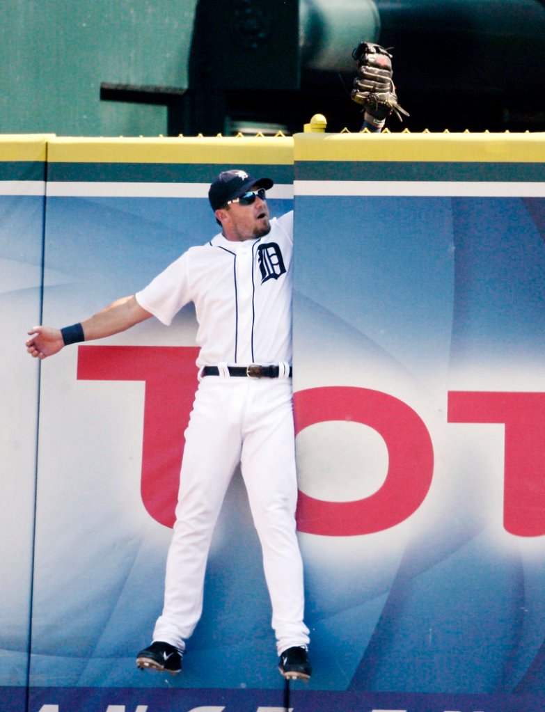 Ryan Raburn of the Tigers gets stuck in the gate after making a leaping attempt on a home run hit by Kansas City’s Mike Moustakas Saturday night.