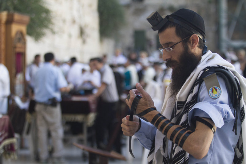 An Israeli soldier prays next to the Western Wall, the holiest site where Jews can pray, in Jerusalem. Secular males must perform three years of military service when they turn 18.