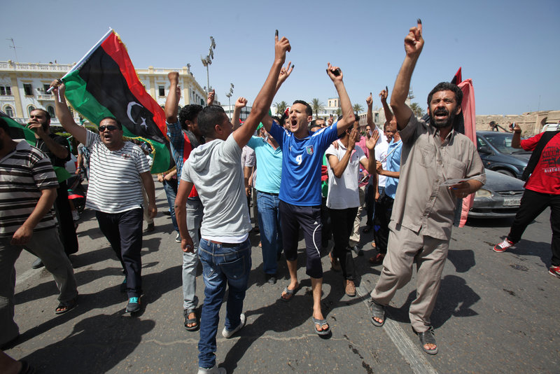 Libyans in Tripoli hold up ink-marked fingers to show they have voted as they celebrate in Martyrs’ Square on Saturday. Observers say Libya, unlike Egypt and Tunisia, could pose a setback to the Muslim Brotherhood by supporting non-Islamist candidates.