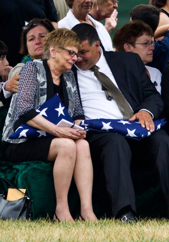 Barbara Annechino is comforted by her brother Jeffrey Christiano during the burial service for their father, Air Force Col. Joseph Christiano of Rochester, N.Y., and five others Monday at Arlington National Cemetery.