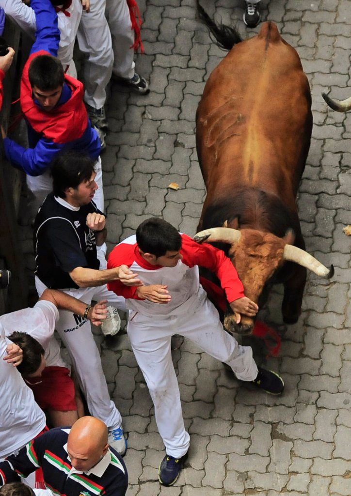 Revelers get out of the way of a bull during the third day of the running of the bulls at the San Fermin festival in Pamplona, Spain, on Monday.