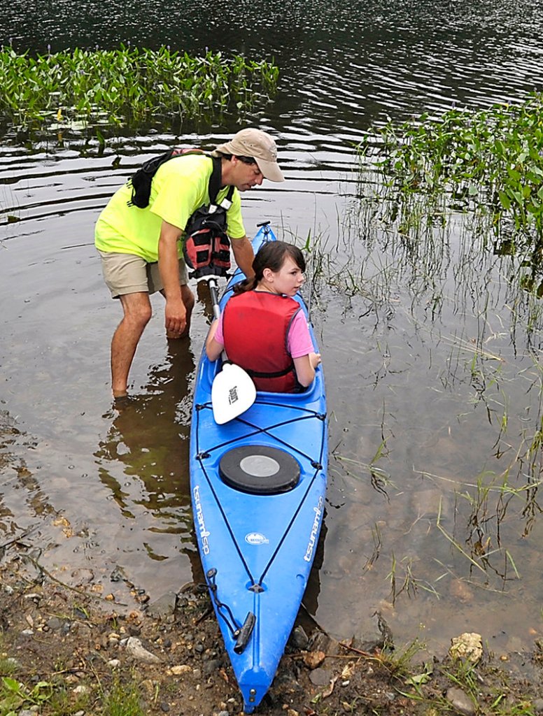 Tournament director Scott Shea helps Michaela Burpee, 11, of Phippsburg get her kayak into the water.