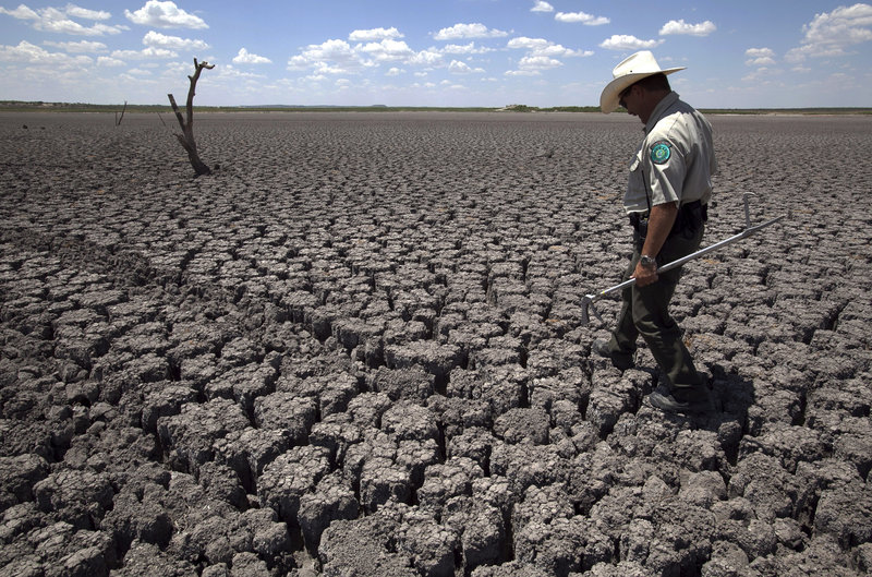Texas State Park police Officer Thomas Bigham walks across the cracked lake bed of O.C. Fisher Lake in San Angelo during 2011’s heat wave. Researchers calculate that global warming has made such a Texas heat wave about 20 times more likely during a La Nina year.