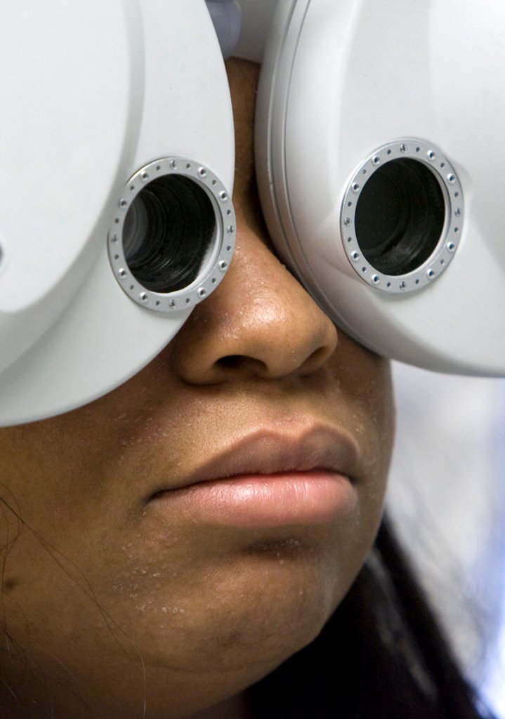 A Kansas City, Kan., woman undergoes a free eye exam on a visit to a mobile clinic May 11. Health plans offered under the Affordable Care Act will cover preventive care, such as flu shots and birth control, at no cost.