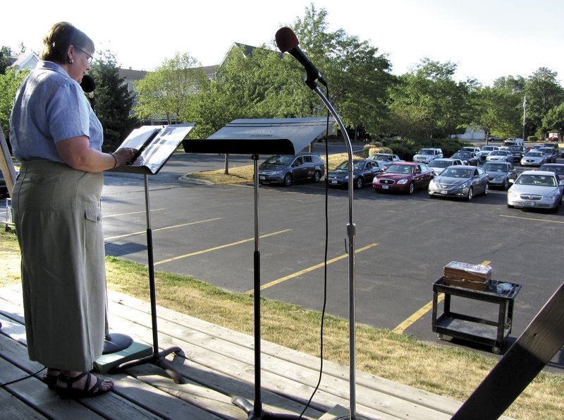 Naomi Garber, pastor of First Lutheran Church, preaches to her congregation by way of their car radios during a typical summer drive-in service in the church’s parking lot last week in Janesville, Wis.