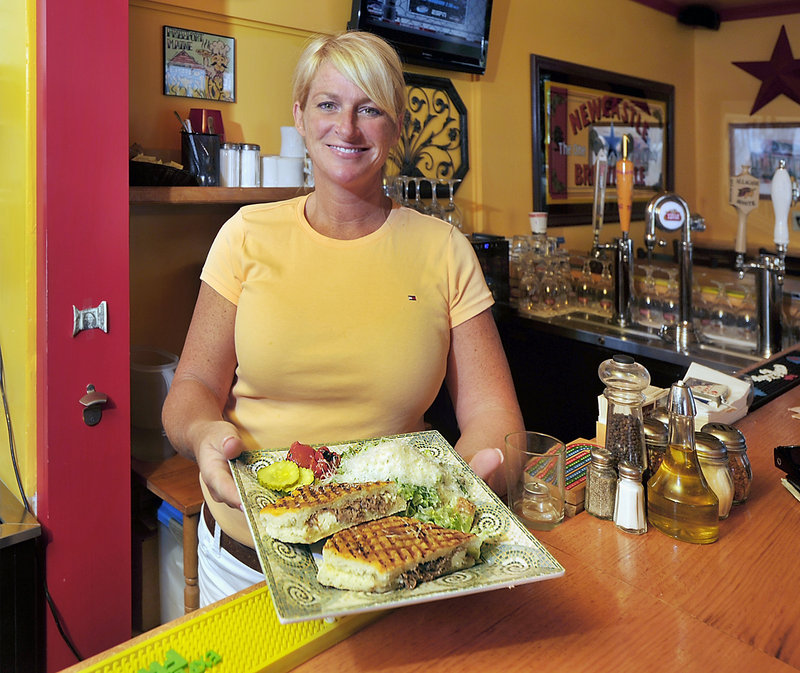Sammi Proulx, a waitress at Petrillo’s on Depot Street in Freeport, presents a roasted garlic, beef and Gorgonzola panini served with a Caesar salad with grated Parmesan cheese, a lunch special for the day.