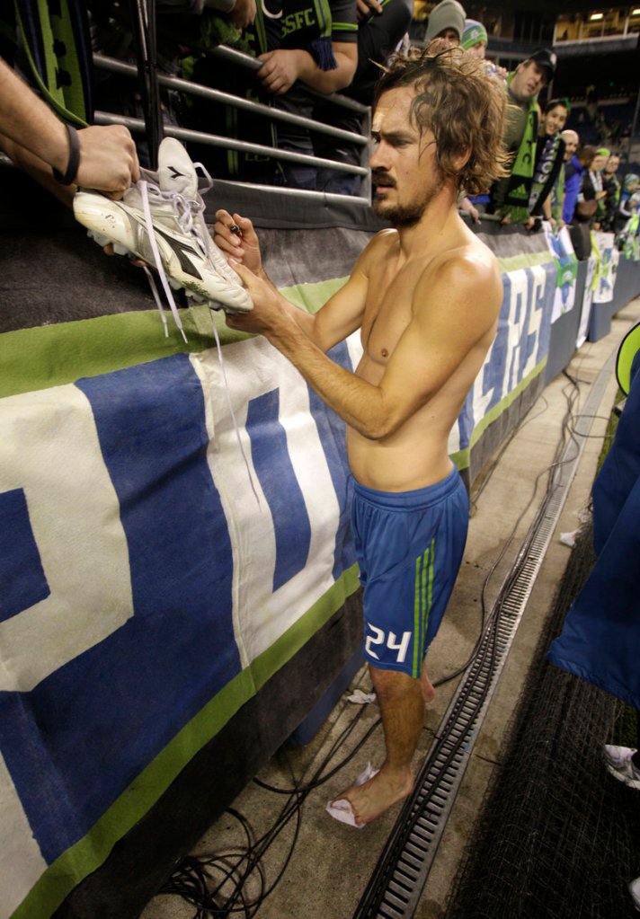 Roger Levesque, a former Falmouth High and Stanford University star, gives away his autographed shirt and shoes after a Seattle Sounders match earlier this year.