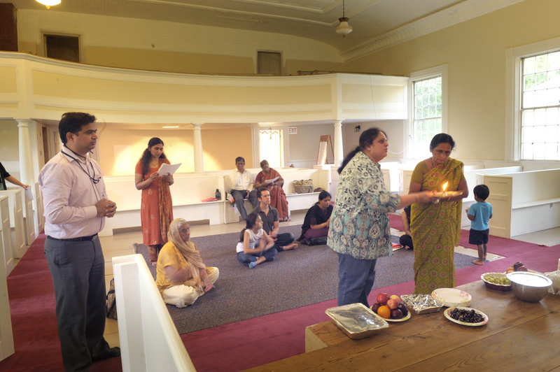 Worshippers pray at the new Hindu temple on the Scarborough-Buxton town line Thursday. The group is still renovating the building and the temple will officially open in the fall. Sandeep Gandra, at left, will serve on the board of directors.