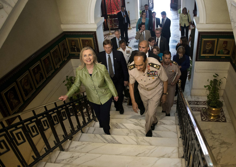 Field Marshal Hussein Tantawi walks with U.S. Secretary of State Hillary Clinton on Sunday at the Ministry of Defense in Cairo. Clinton urged a return of Egypt’s military to a “purely national security role.” Tantawi replied that no one will distract the military from its purpose.