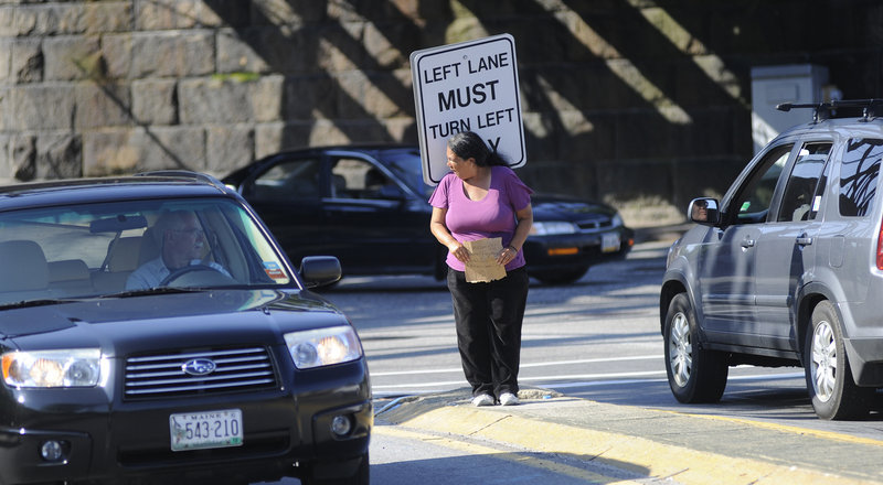 Kelly Noble of Portland panhandles from the median strip at St. John Street and Park Avenue in Portland on Thursday. A proposed ordinance that would prohibit panhandlers from standing in the median will go before the Portland City Council today.
