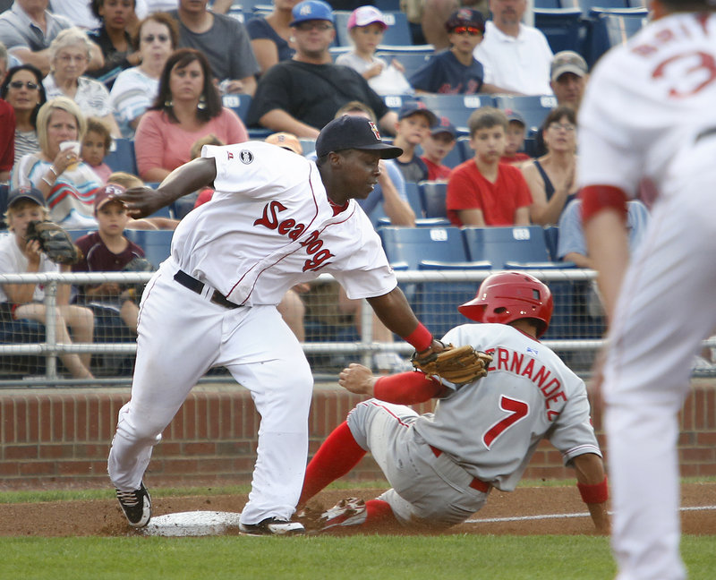 Marquez Smith of the Sea Dogs slaps on a tag too late on Reading’s Cesar Hernandez in the first inning at Hadlock Field Monday night. Reading scored four times in the inning to win, 11-4.