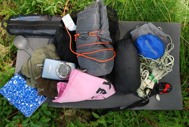 Ultra-light hikers carry little gear. Ryan Linn’s backpack contains, clockwise from the top: an insect net, rain pants, first-aid pouch, bear rope, head lamp, bandanna, camera, journal, socks, spoon and toiletry pouch.