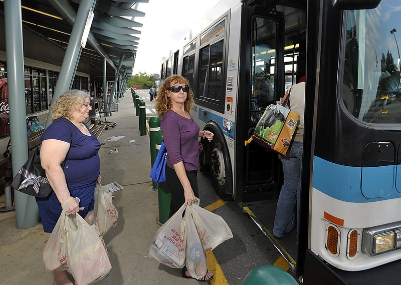 Janet Burgess, a West End resident, boards a Metro bus at the Forest Avenue Hannaford supermarket. She says she misses the convenience of a car, but not the bills that came along with car ownership.
