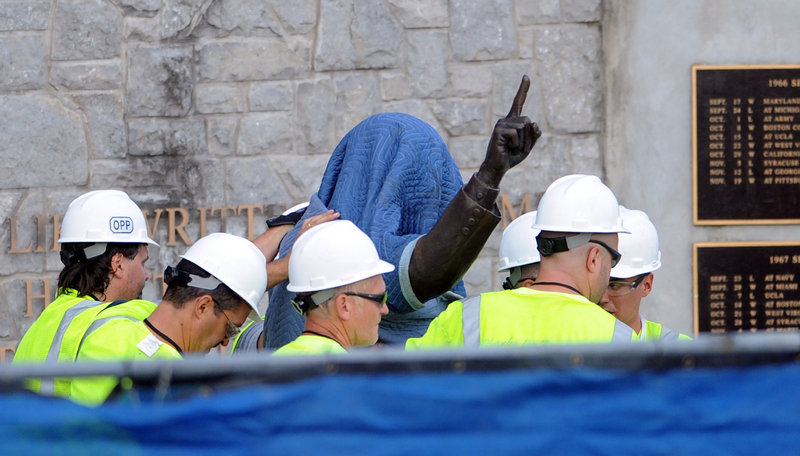 Penn State Office of Physical Plant workers cover the statue of former football coach Joe Paterno before removing it from its site near Beaver Stadium on Penn State’s campus in State College, Pa., on Sunday.