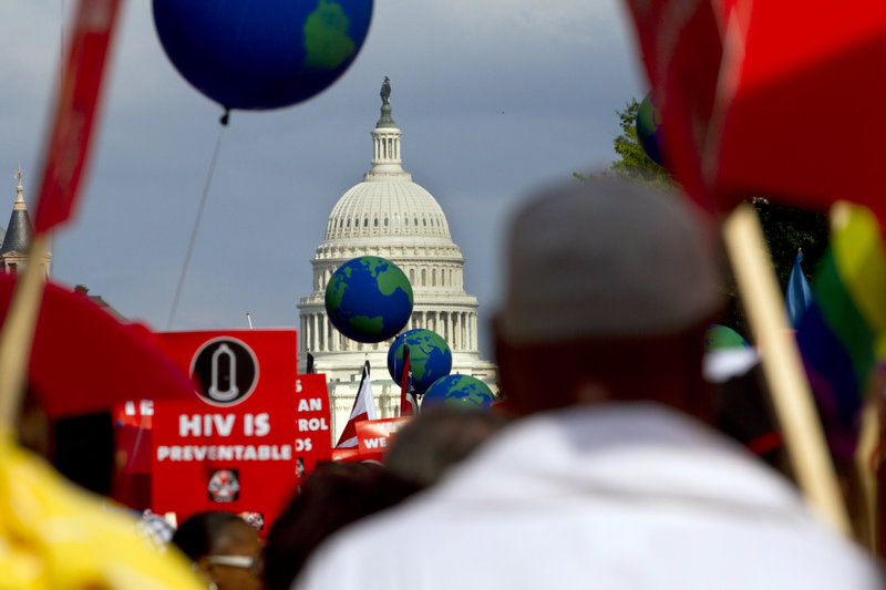 People hold signs and balloons as they participate in the AIDS March in Washington, D.C., on Sunday to urge the public and policymakers to pay more attention to the disease.
