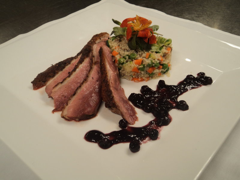 Spice-rubbed pan-seared duck breast with organic farmed vegetables, quinoa and blueberry-red wine sauce is offered by Mitchell Kaldrovich, chef at the Sea Glass Restaurant at Inn by the Sea in Cape Elizabeth.