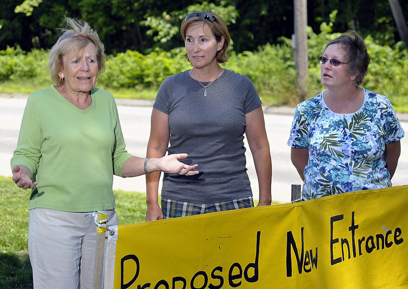 Friends of Oak Hill, from left, Joan Jagolinzer, Lisa Ronco and Stephanie Ruel discuss their concerns about the assisted living project proposed for the wooded area behind them.