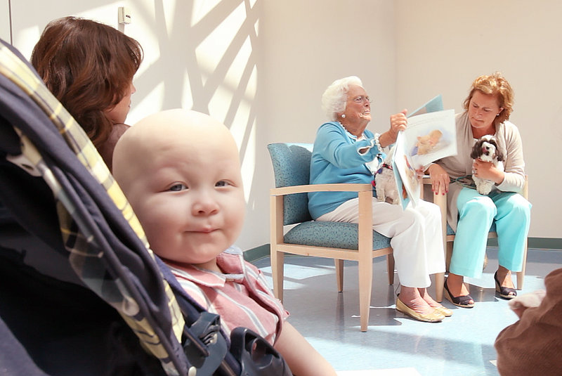 Joshua McIntosh, 2, of Leeds listens while former first lady Barbara Bush reads a book to children at the Barbara Bush Children’s Hospital at Maine Medical Center in Portland on Tuesday. With Bush is her daughter, Doro Bush Koch.