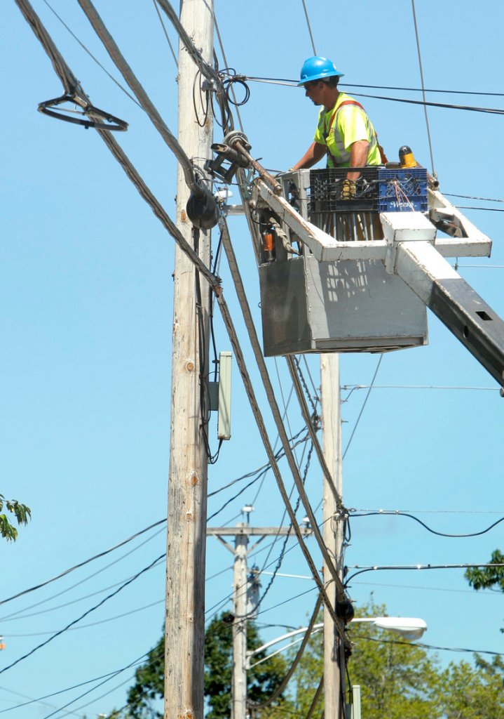 Ericson Estes of NextGen, a telecommunications company, works on a support line on Route 1 in Wells. The entirely above-ground network is strung along 29,000 utility poles.