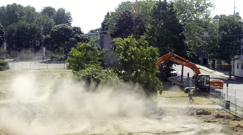 A dust cloud rises Monday as a tree is felled on the site of the former Adams School. Dust levels will be more closely monitored after residents complained.