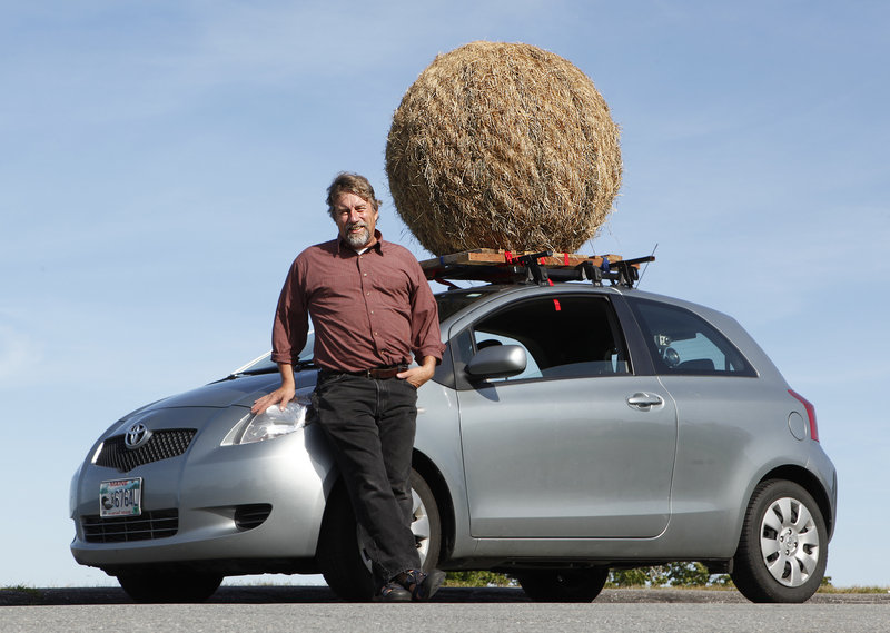 Portland artist Michael Shaughnessy and the Hay Ball, mounted atop his car. Shaughnessy has a Facebook page for the artwork, and invites photographs of it.