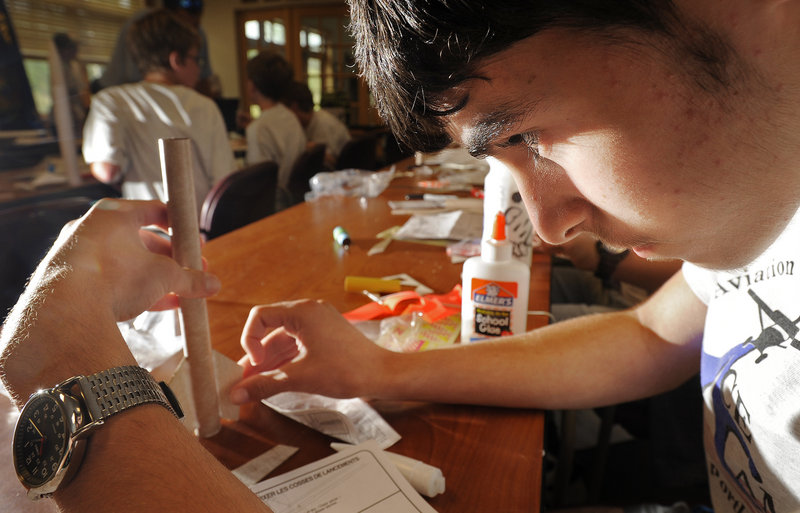 Camper Steven Larkin, 13, of Scarborough, puts all his concentration into gluing a fin to a rocket Thursday at Aviation Careers Education camp being held at the Boy Scout conference facility near the Portland Jetport. Eighteen teenagers are participating in the camp.