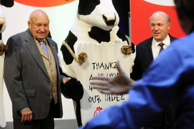 Chick-fil-A founder Truett Cathy, left, and his son Dan Cathy pose for a photo with the Chick-fil-A cows during a celebration of passing the $3 billon mark in system-wide sales in Atlanta in 2009.