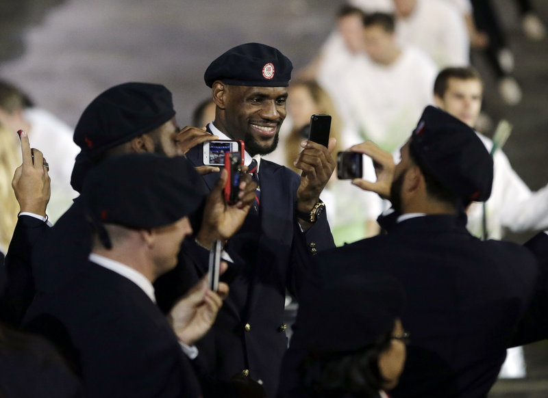 LeBron James of the Miami Heat, and a member of the U.S. men’s basketball team, takes pictures Friday night along with other American athletes while parading into the stadium during the opening ceremonies in London.