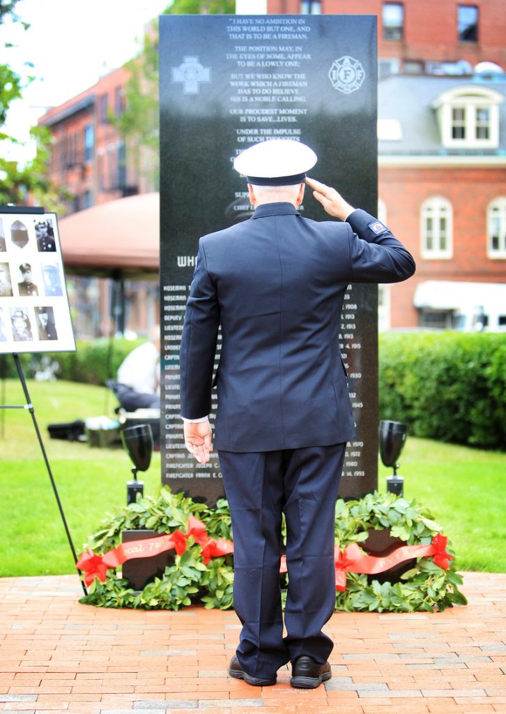 Lt. Edward Marks, retired, of South Portland, president of the Portland Veteran Firemen’s Association, salutes after placing a wreath at the memorial in Portland on Saturday.