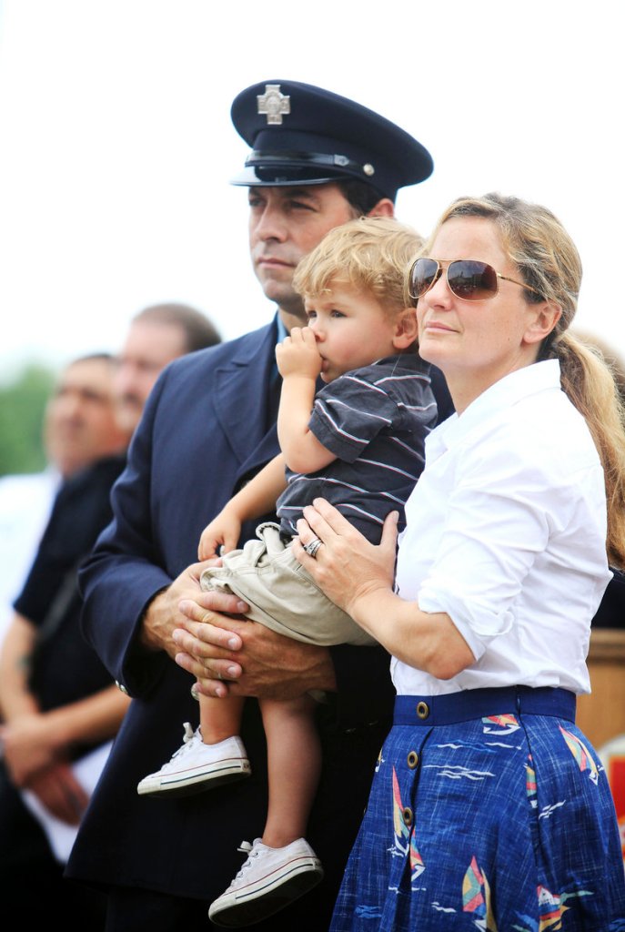 Firefighter Tyler Nash of Cumberland stands with his son Kelsey, 18 months, and his wife, Bethany, during the ceremony.