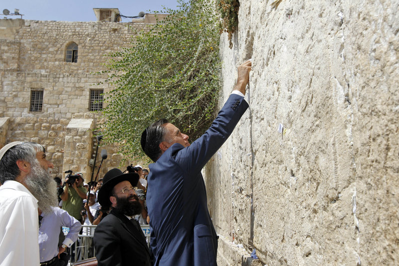 Republican presidential candidate and former Massachusetts Gov. Mitt Romney places a prayer note as he visits the Western Wall in Jerusalem on Sunday.