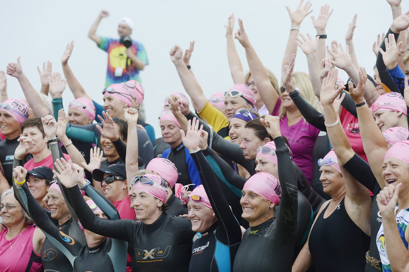 Cancer survivors pose for photos before the start of the Tri for a Cure on Sunday.