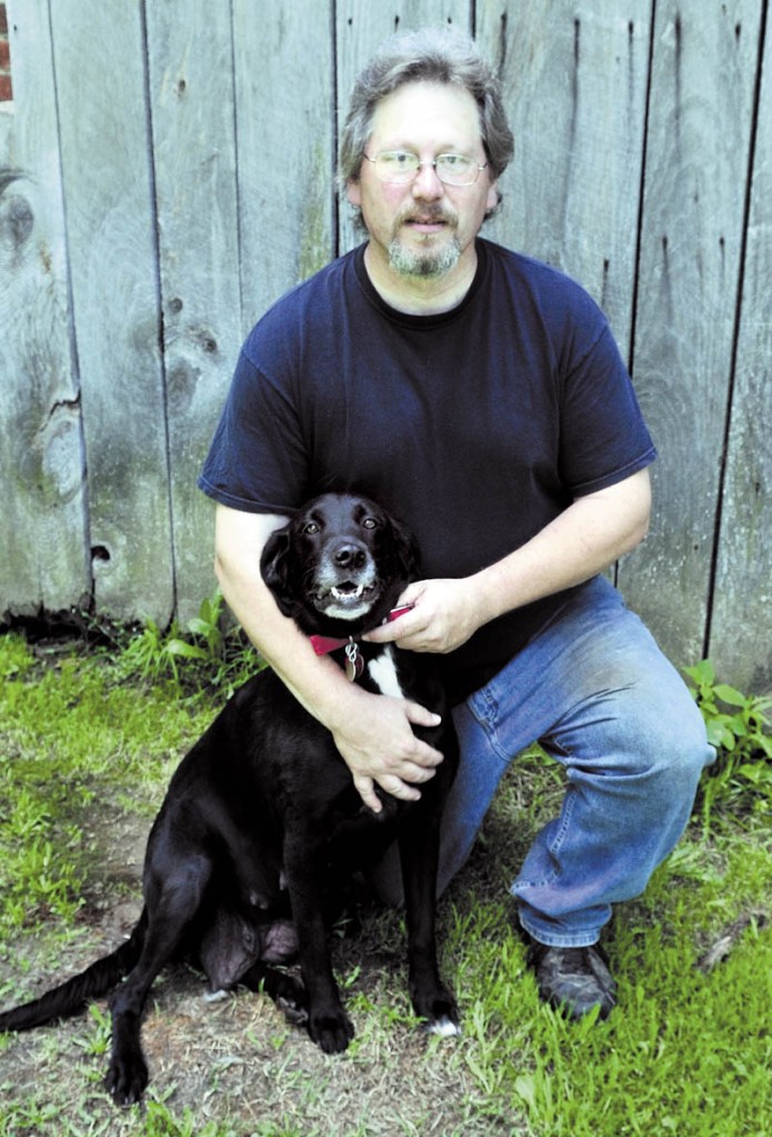 Mike Topich with his dog Molly Belle in Thorndike on Sunday. Tragedy struck recently when a rabid skunk attacked 11 puppies before Topich intervened. The puppies had to be euthanized and Topich had to receive treatment for rabies exposure.