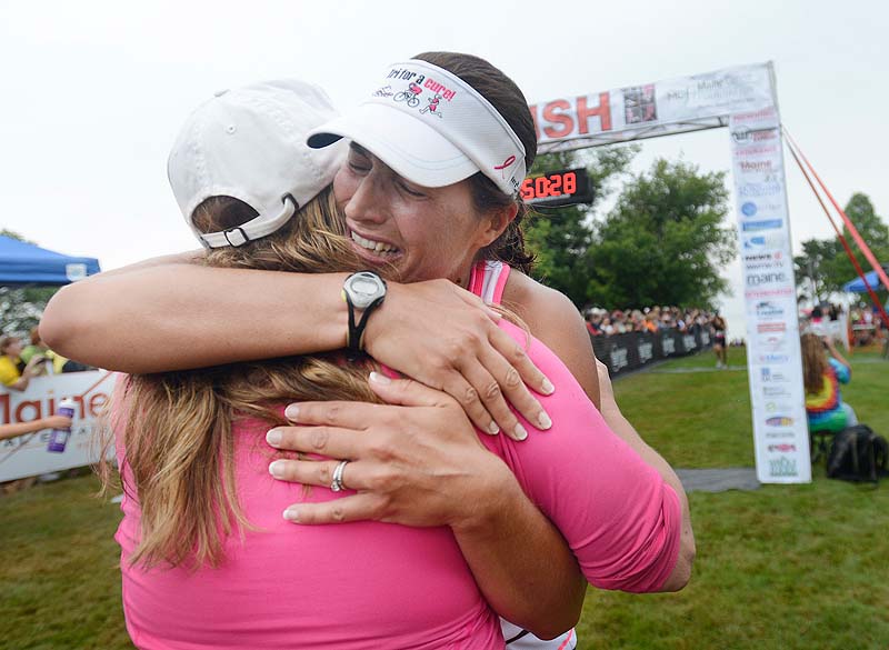 Sharon Leddy-Smart of South Portland, a breast cancer survivor, cries as she is greeted at the finish line by her cousin, Samantha Smith of Falmouth, who was recently diagnosed with cancer.