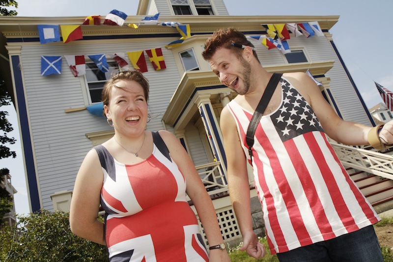 Madeleine Paine and Jake Hancock, dressed in flags, stand in front of Paine's home at 150 Eastern Promenade Ave. that was decorated for the Mumford & Sons concert on Saturday.