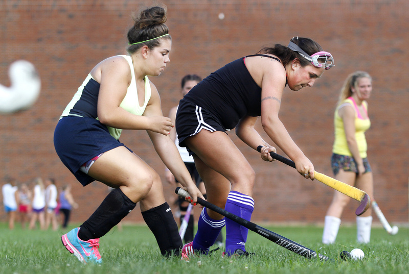 Kiana DiBiase, left, and Maya Hanna battle for the ball during Deering’s opening field hockey practice.