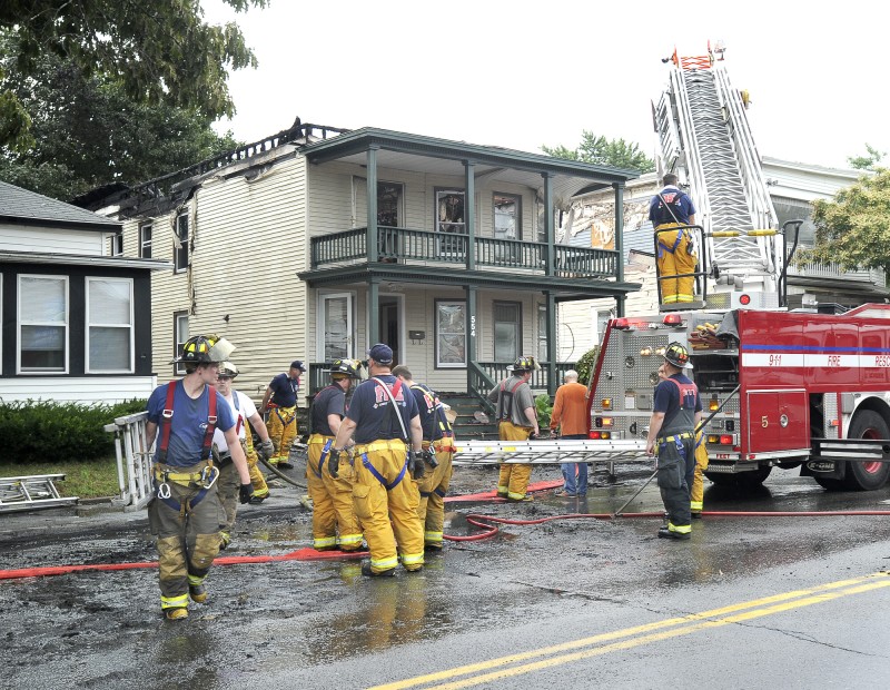 South Portland firefighters mop up after a fire destroyed a house at 554 Main St. in South Portland early Wednesday morning.