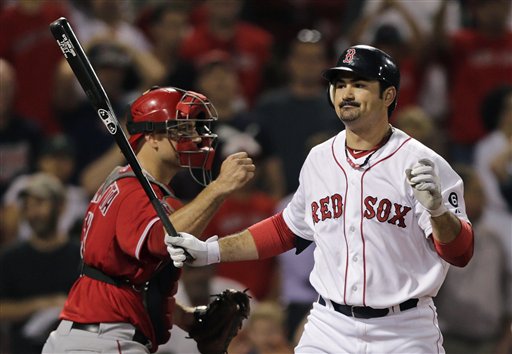 Boston Red Sox's Adrian Gonzalez, right, reacts as he strikes out swinging to end the game Thursday night. The Red Sox are close to trading Gonzalez, Josh Beckett and Carl Crawford to the Dodgers in a blockbuster deal. (AP Photo/Charles Krupa)