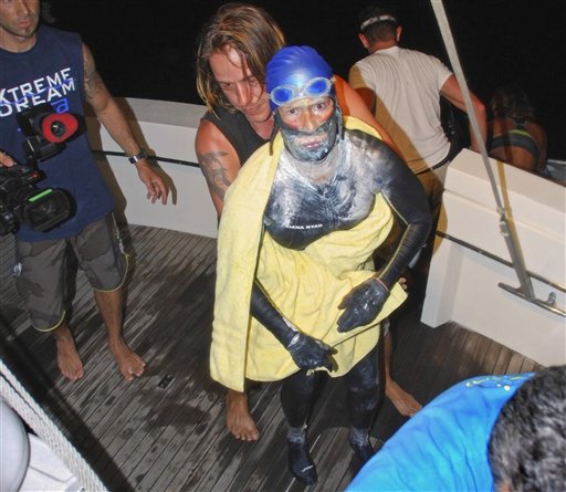 Diana Nyad is aided after she was pulled out of the water between Cuba and the Florida Keys early Tuesday, ending her fourth bid to swim from Cuba to Florida after four days of storms, jellyfish stings and shark threats.