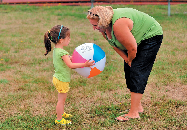 Nora Taylor, 3, looks to her grandmother Tina Couturier to play with a beach ball during the Family Fun Day.