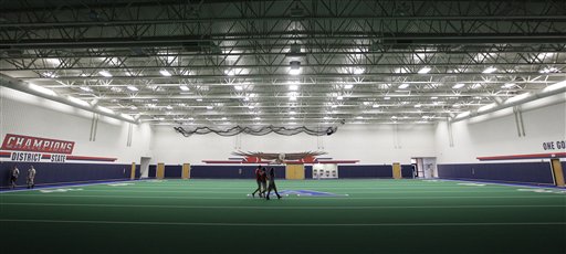Students walk across the new indoor practice field that is part of the new $60 million football stadium at Allen High School.