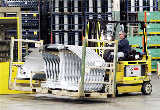 A worker at the Ford Stamping Plant moves a stack of Lincoln MKS body sides in Chicago Heights, Ill. The U.S. economy grew at a 1.7 percent annual rate in the April-June 2012 quarter, boosted by slightly stronger consumer spending and greater imports.
