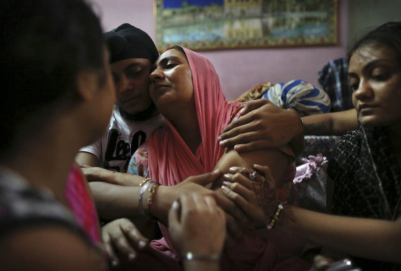 Indian Surinder Kaur, center, the wife of Seeta Singh who was killed in the shooting attack at a Sikh temple in Wisconsin, is comforted by her son Armeet and daughter Sarabjit, right, at the family home in New Delhi, India, Tuesday, Aug. 7, 2012. Singh was killed alongside his brother Ranjeet Singh who he had recently joined in the United States during the attack on Sunday. (AP Photo/Kevin Frayer)