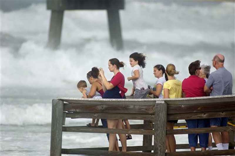 A crowd gathers on the end of the boardwalk on Okaloosa Island in Fort Walton Beach, Fla., Tuesday, Aug. 28, 2012 to watch rough surf generated by Hurricane Isaac as it moves through the Gulf of Mexico with an expected landfall in Louisiana. (AP Photo/Northwest Florida Daily News, Devon Ravine)